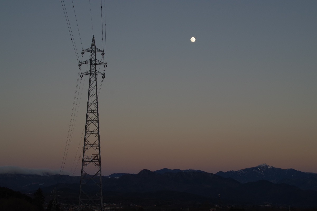 「夕暮れ時の月と鉄塔」